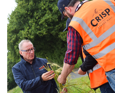 Two males assess crops in field during open day