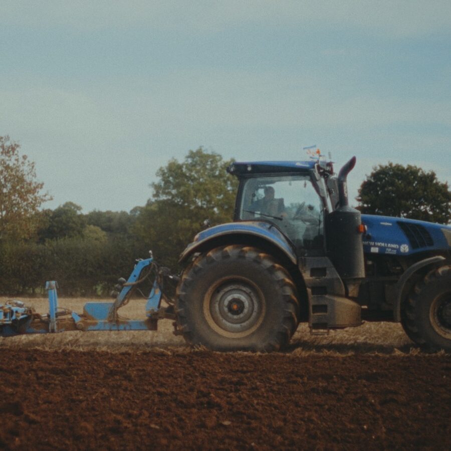 A tractor ploughs a field in Norfolk, UK, to signify the sustainable supply of grain